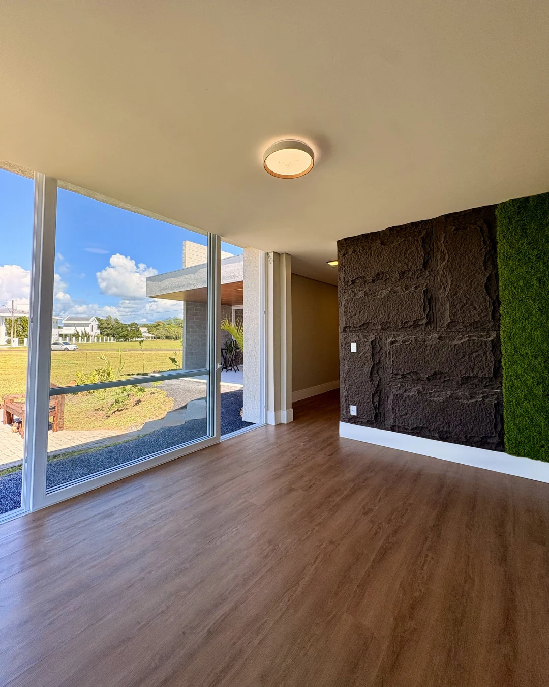 Suíte com piso laminado, jardim vertical e vista aberta
